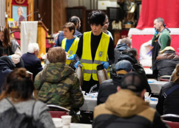 La ministra Elma Saiz se suma al reparto solidario del padre Ángel en San Antón: «Dadles vosotros de comer»